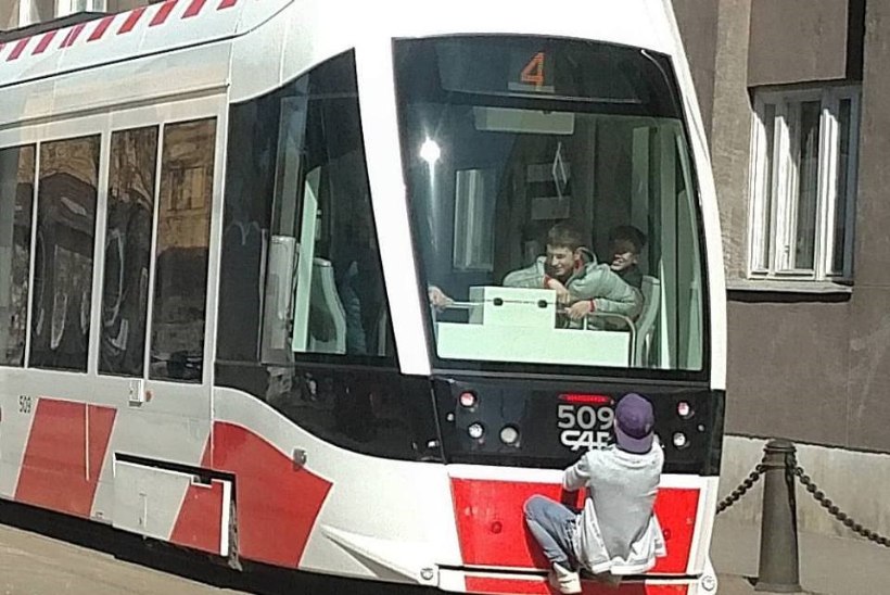 Tallinnas rippus nooruk sõitva trammi küljes