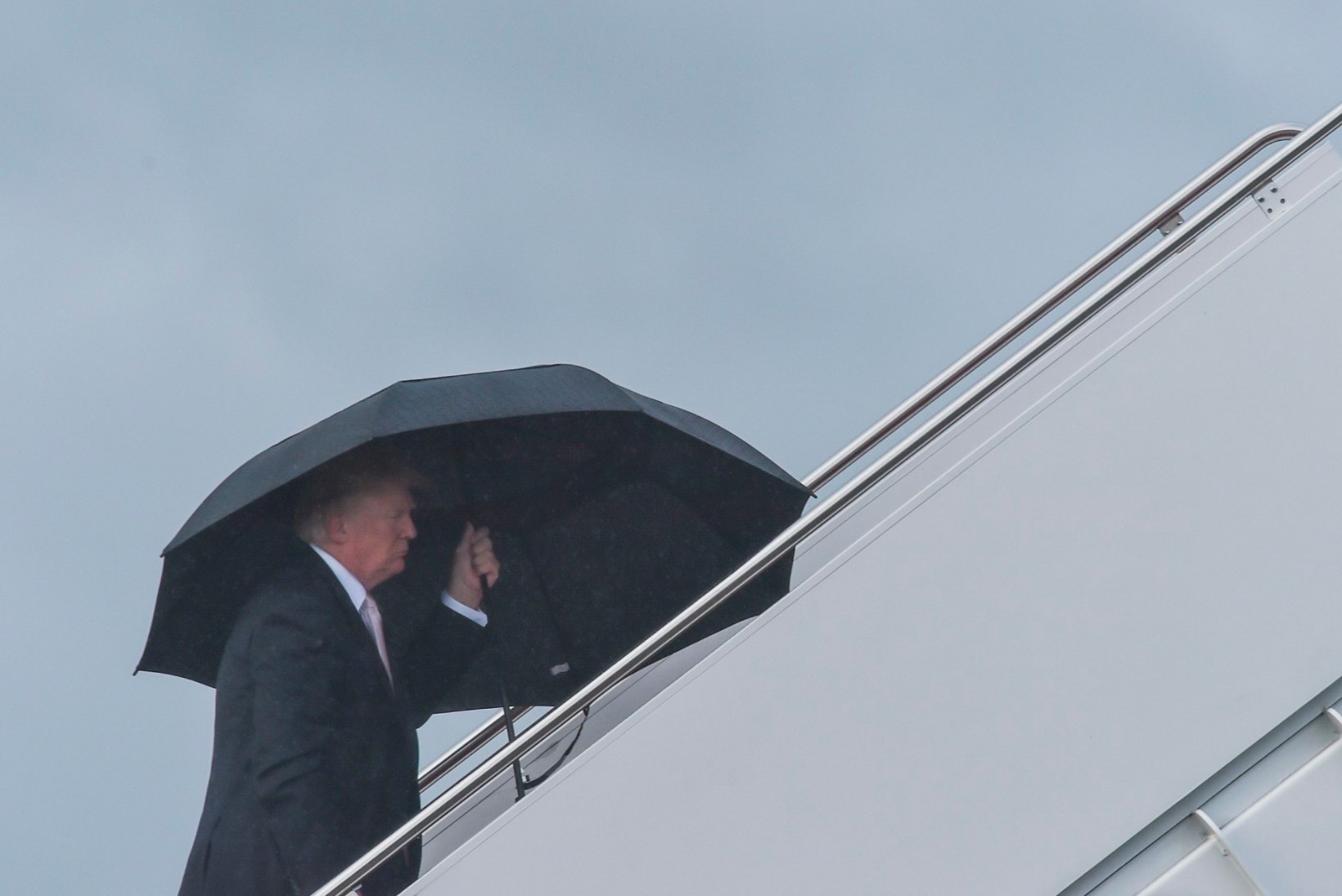 FOTOD | Trump hoiab enda kohal suurt vihmavarju, jättes naise ja poja saju kätte 